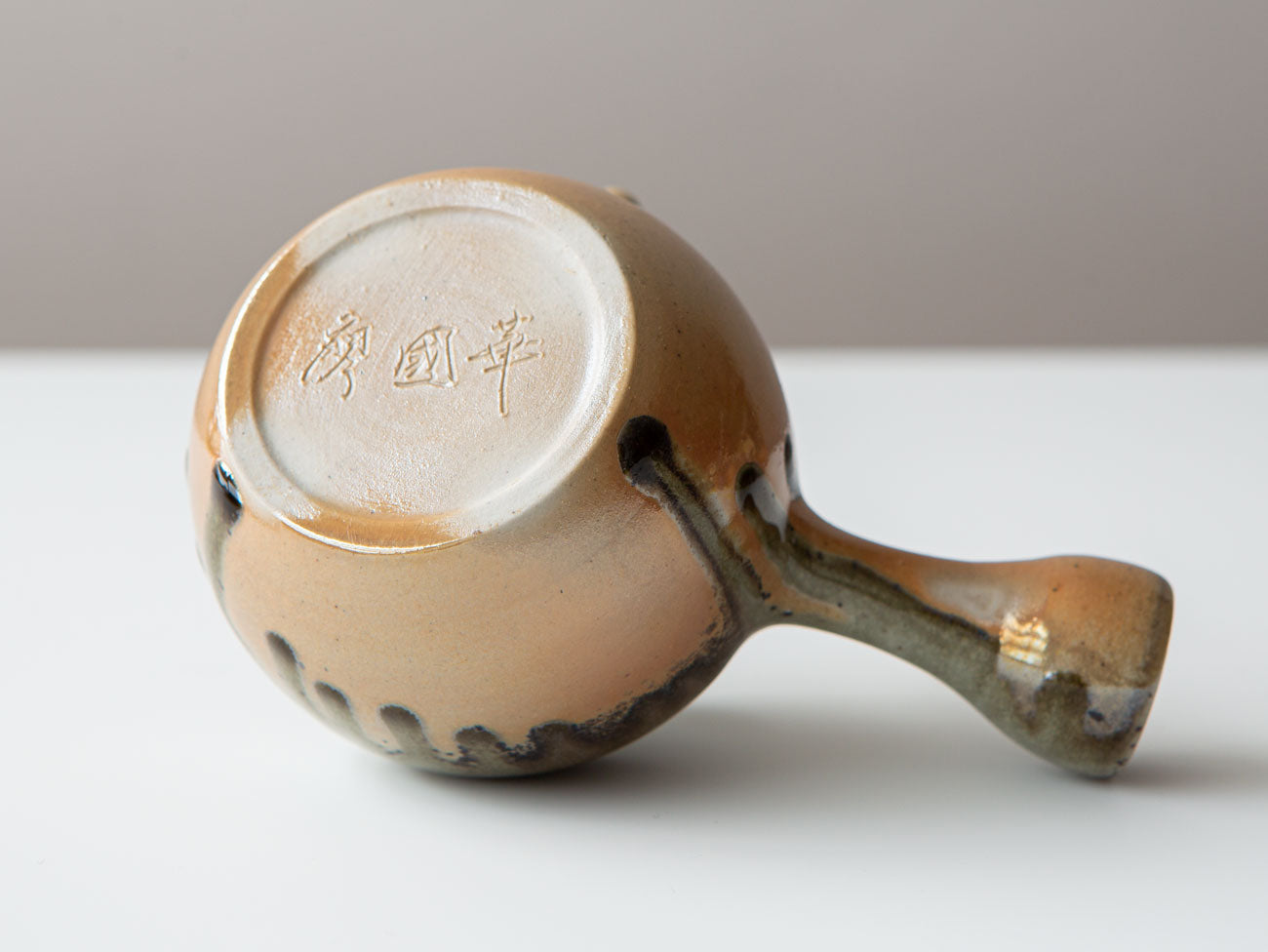 Ink + Gold. Underside, unglazed, with artist's carved signature.