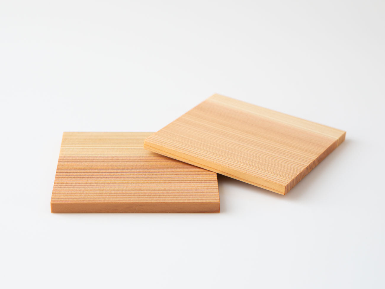 A pair of white cedar tea coasters.