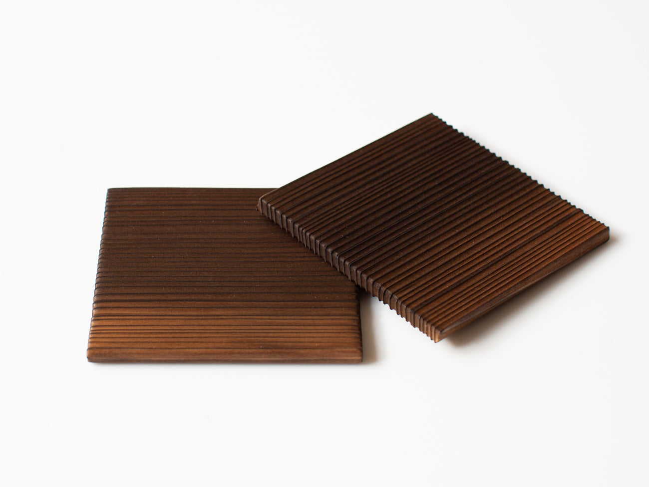 A pair of burnt cedar coasters.